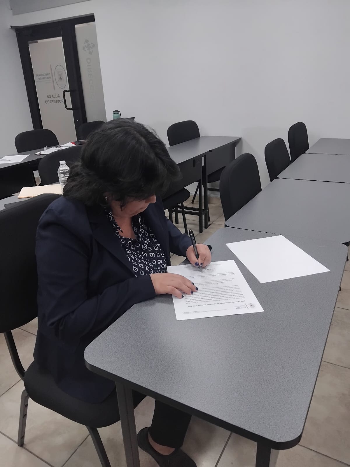 La licda. Ingrid reyes durante la firma de actas de su defensa de tesis oral y pública.